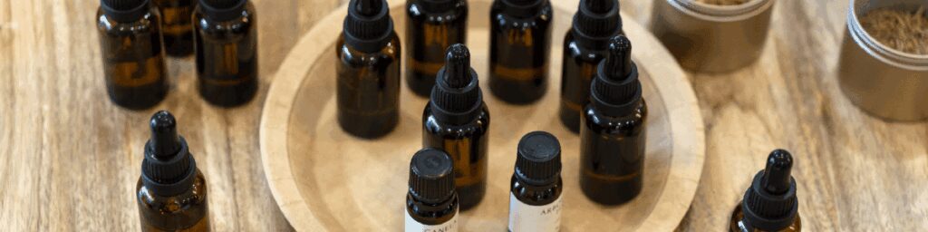Flacons d'huile essentielle contenant du géraniol, utilisés pour leurs propriétés répulsives et aromatiques.